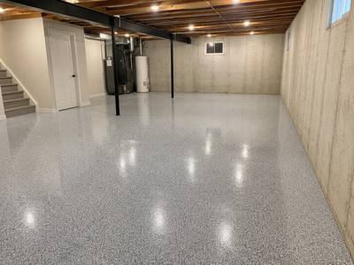 Grey flake coating across a basement slab beside the furnace