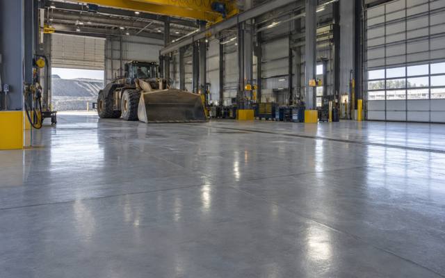 High bay mining supply workshop in Greater Sudbury with a grey resin floor under an overhead crane